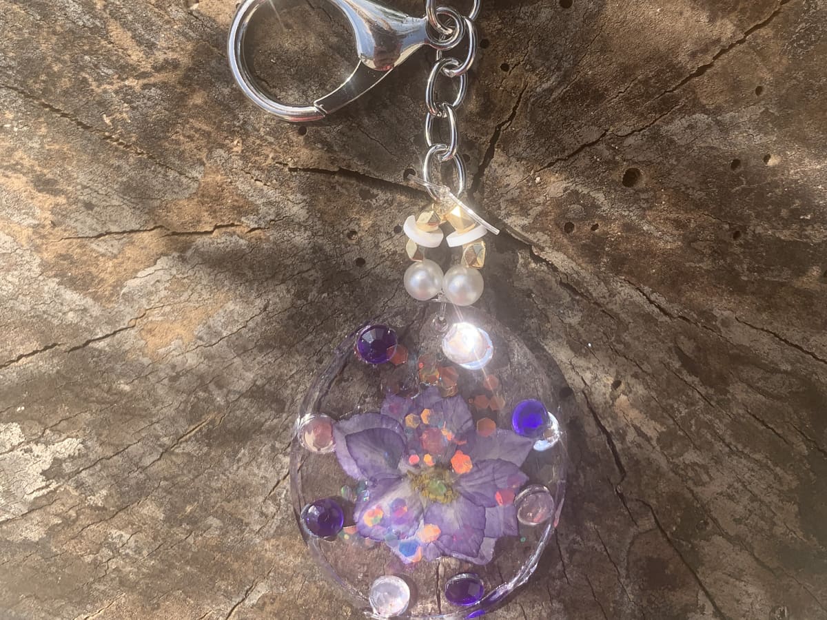 Porte-clé argenté avec pensées violettes en résine