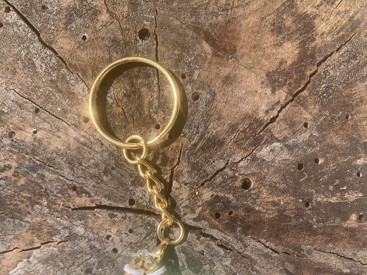 Porte-clé doré avec trèfle à quatre feuilles et perles nacrées